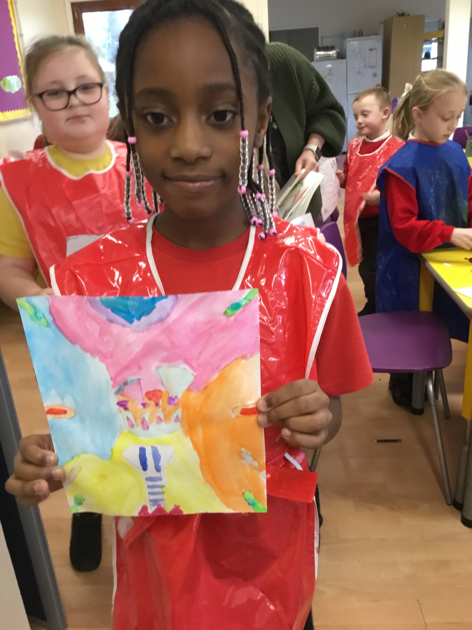 A child holding up their painting