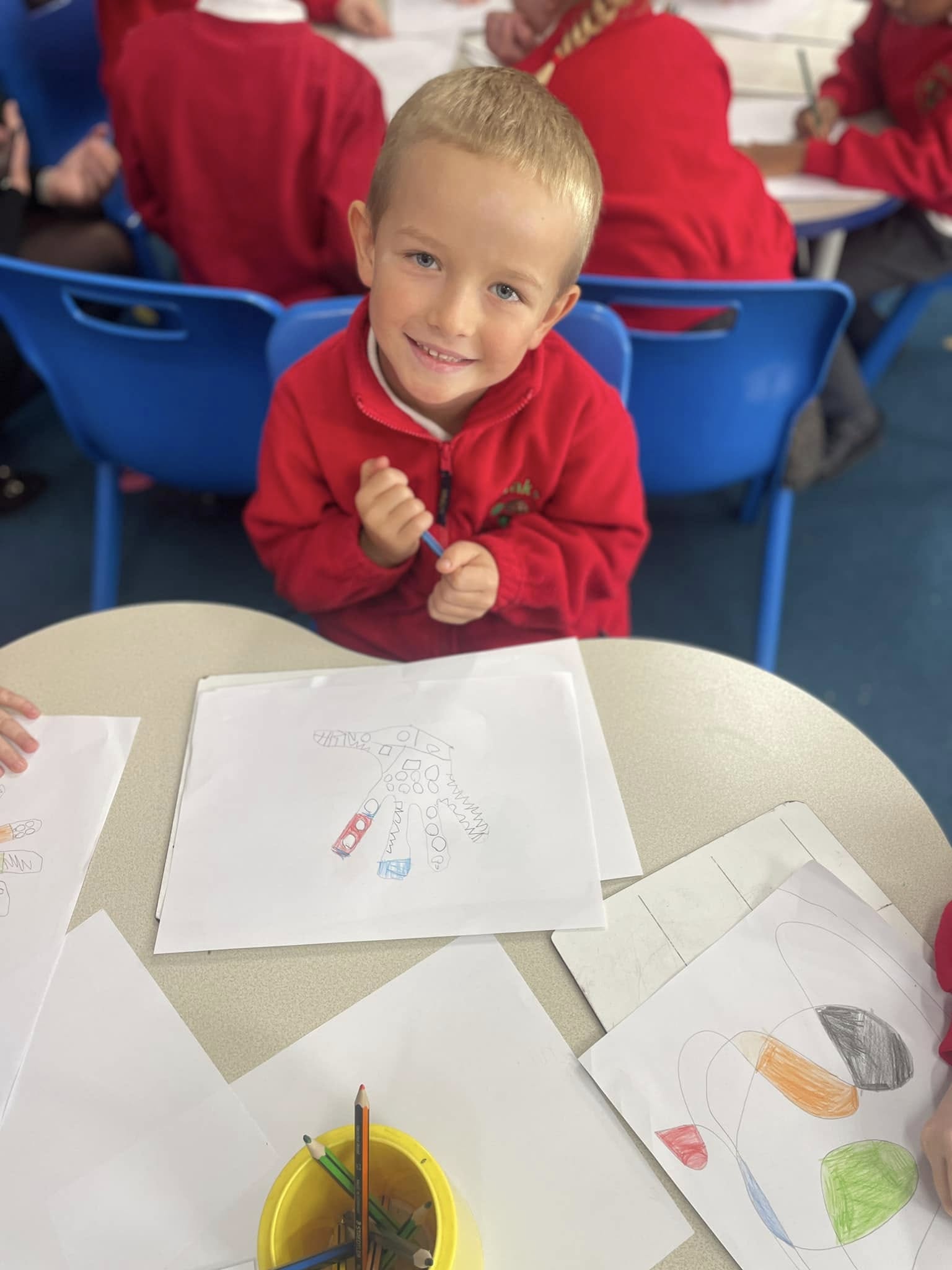 A child at a table, smiling
