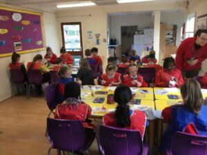 Children sat at tables painting