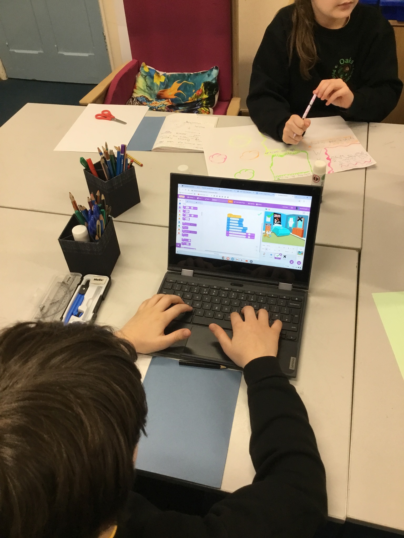 An overhead view of a child's hands working on a laptop